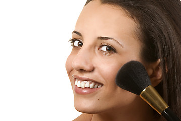 Image showing young woman applying blusher