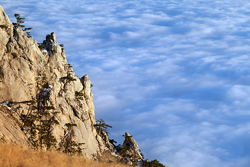 Image showing Sunlit cliffs and sea in clouds