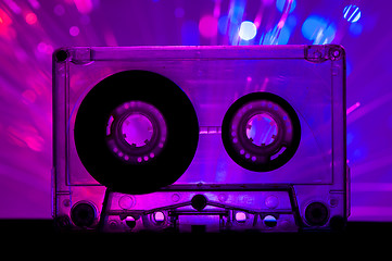 Image showing Transparent Cassette tape and disco light background