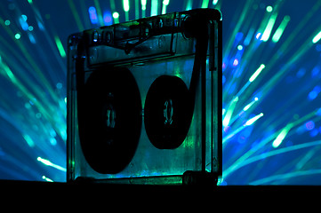 Image showing Transparent Cassette tape and disco light background