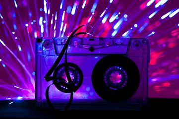 Image showing Transparent Cassette tape and disco light background