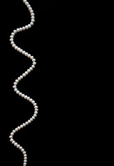 Image showing White pearls on the black silk as background 