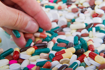 Image showing hand grabbing pills