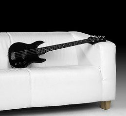 Image showing black bass guitar and white couch