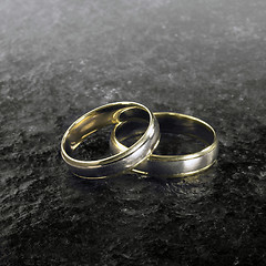 Image showing two golden wedding rings on stone surface