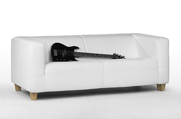 Image showing black bass guitar on white couch