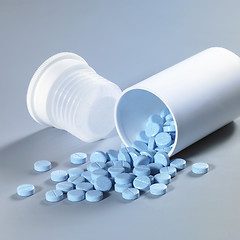 Image showing blue pills and can