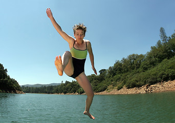 Image showing Young woman jumping in the lake