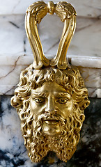 Image showing decorative gold face on a marble bowl in the museum.