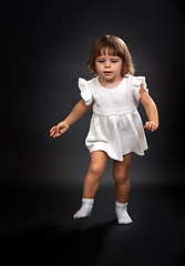 Image showing the first steps of a little girl on a black background.