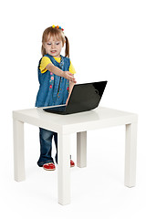 Image showing little girl with a laptop at a table