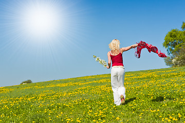 Image showing young woman with a red scarf on a meadow