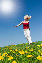 Image showing young woman in red outfit having fun on meadow