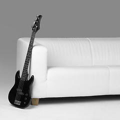 Image showing black bass guitar and white couch