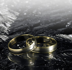 Image showing two golden wedding rings on ice surface
