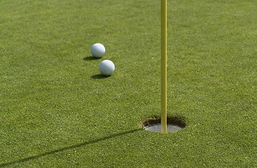 Image showing hole and golf balls in green back