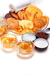 Image showing floral tea set and pastry assortment over white