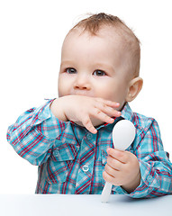 Image showing Cute little boy is biting his finger