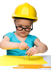 Image showing Little girl is playing while wearing hard hat