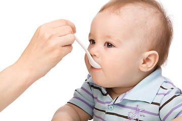 Image showing Little boy is being feed by his mother