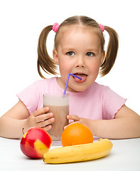 Image showing Little girl drinks fruit juice