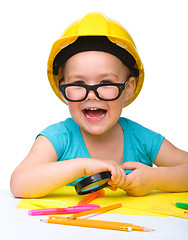 Image showing Cute little girl is playing while wearing hard hat