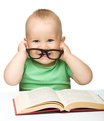 Image showing Little child play with book and glasses