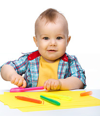 Image showing Happy little boy is playing with colorful markers