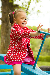 Image showing Cute little girl is swinging on see-saw