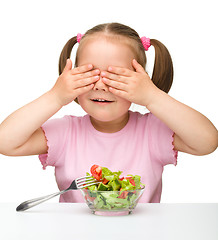 Image showing Cute little girl eats vegetable salad