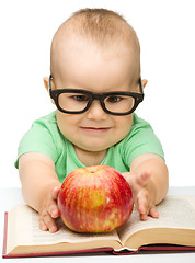 Image showing Little child is playing with red apple