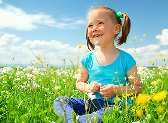 Image showing Little girl is playing on green meadow