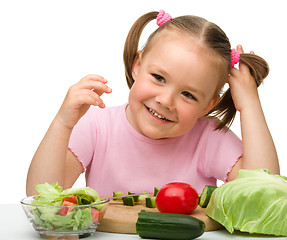 Image showing Little girl is cutting carrot for salad