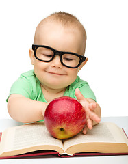 Image showing Little child is playing with red apple