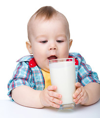 Image showing Cute little boy is going to drink milk from glass