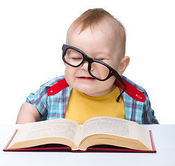 Image showing Little child play with book and glasses