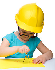 Image showing Little girl is playing while wearing hard hat