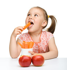 Image showing Cute little girl eats carrot and apples