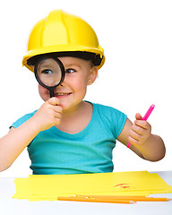 Image showing Cute little girl is looking through magnifier