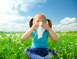 Image showing Little girl is blowing her nose