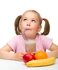 Image showing Little girl drinks fruit juice