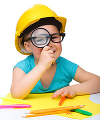 Image showing Cute little girl is looking through magnifier