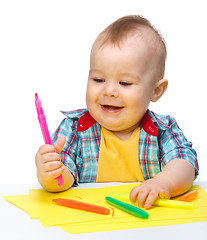 Image showing Happy little boy is playing with colorful markers