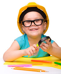 Image showing Cute little girl is playing while wearing hard hat