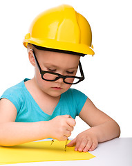 Image showing Little girl is playing while wearing hard hat