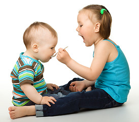 Image showing Sister is feeding her little brother