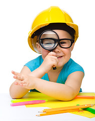 Image showing Cute little girl is looking through magnifier