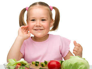 Image showing Little girl is cutting carrot for salad