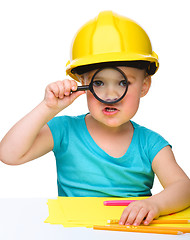 Image showing Cute little girl is looking through magnifier