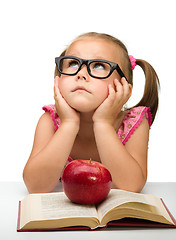 Image showing Little girl is sitting bored with a book
